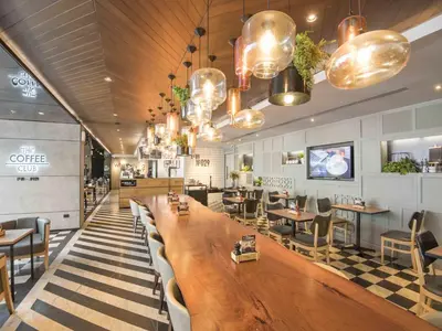 a restaurant with a large wooden table and chairs at Maitria Hotel Sukhumvit 18 Bangkok – A Chatrium Collection in Bangkok