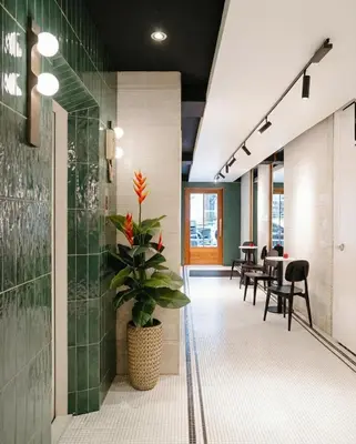 an office corridor with tables and chairs and a plant at Grand Inn Hotel in Bangkok