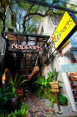 a restaurant with a sign on the side of a building at Nappark Hostel @Khao San in Bangkok