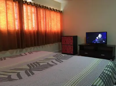a bedroom with a bed and a flat screen tv at Condo Muang Thong in Nonthaburi