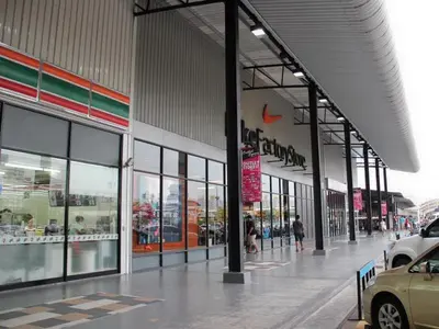a store front with people walking in front of it at Condo Muang Thong in Nonthaburi