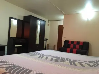 a bedroom with a bed and a black chair at Condo Muang Thong in Nonthaburi