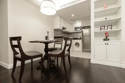 a kitchen with a table and chairs and a refrigerator at Bliston Suwan Park View in Bangkok