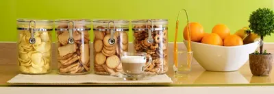 a table with jars of food and a bowl of oranges at The Inn Saladaeng in Bangkok