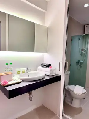 a bathroom with a sink and a toilet and a mirror at Nantra de Comfort in Bangkok