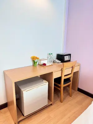 a wooden desk with a printer and a microwave at Nantra de Comfort in Bangkok