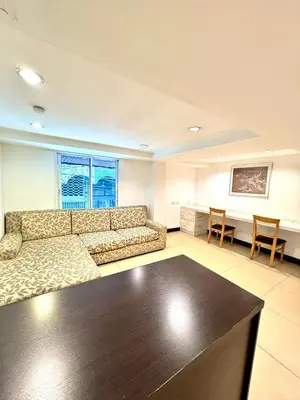a living room with a couch and a table at Nantra de Comfort in Bangkok