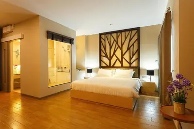 a bedroom with a bed and a bathroom at Green Point Residence Hotel in Bangkok
