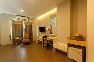 a hotel room with a table and a dining room at Green Point Residence Hotel in Bangkok