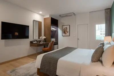 a bedroom with a bed and a desk and a television at The Legacy Hotel Nana Sukhumvit, Aspira Collection in Bangkok