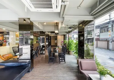a restaurant with tables and chairs in a building at Ton Aor Place Hotel in Bangkok