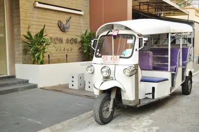 a small white vehicle parked in front of a building at Ton Aor Place Hotel in Bangkok