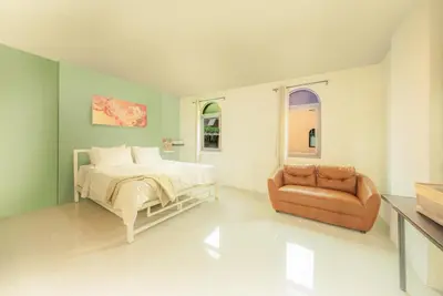 a bedroom with a bed and a couch at Baansuanprannok Hotel in Bangkok