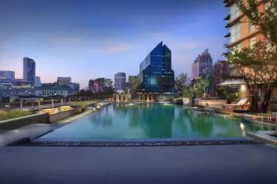a swimming pool with a city skyline in the background at Sathorn Vista, Bangkok - Marriott Executive Apartments in Bangkok