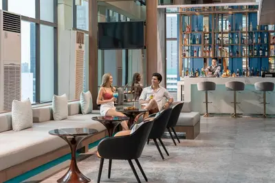 a group of people sitting at a table in a lobby at Renaissance Bangkok Ratchaprasong Hotel by Marriott in Bangkok