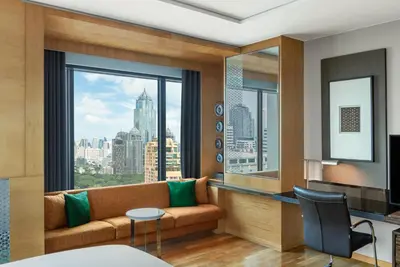 a living room with a couch and a large window at Renaissance Bangkok Ratchaprasong Hotel by Marriott in Bangkok