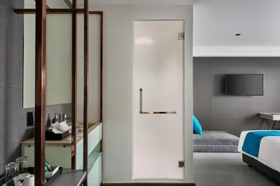 a room with a door leading to a bedroom at Sora Hotel Silom in Bangkok