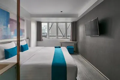 a hotel room with a bed and a television at Sora Hotel Silom in Bangkok