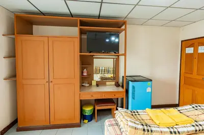 a bedroom with a desk and a bed and a tv at Tat Hotel in Bangkok