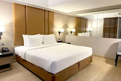 a large white bed in a hotel room at Ramada Sukhumvit Soi Eleven in Bangkok
