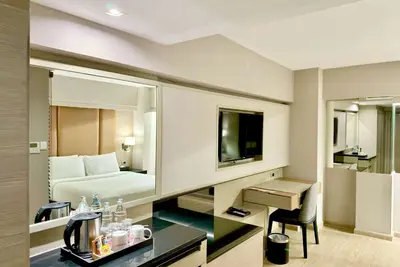 a hotel room with a bed and a desk at Ramada Sukhumvit Soi Eleven in Bangkok