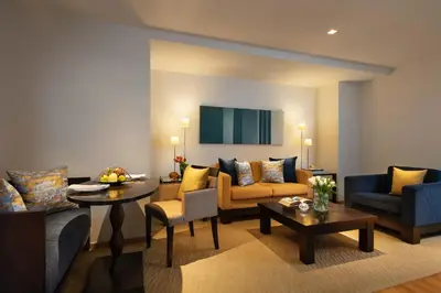 a living room with couches and a table at Tower Club at lebua in Bangkok