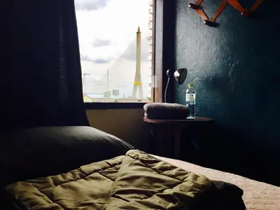 a bedroom with a bed and a window with a view at Hidden Lumpu in Bangkok