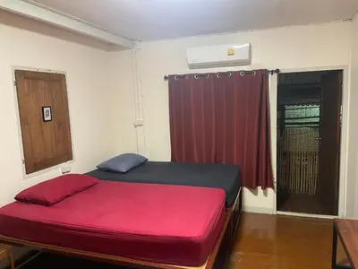 a bedroom with a bed with a red blanket at Hidden Lumpu in Bangkok