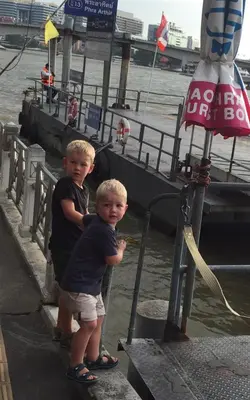 two young boys standing on a dock near the water at Hidden Lumpu in Bangkok