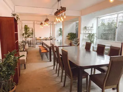 a dining room with a long table and chairs at Pillow & Bread Hostel in Bangkok
