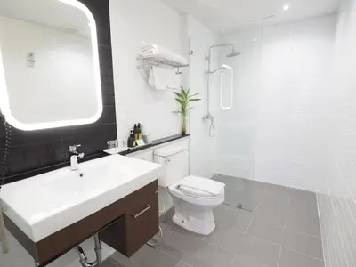 a bathroom with a sink and a toilet and a shower at Evergreen Place Siam by UHG in Bangkok