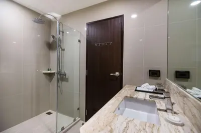 a bathroom with a sink and a glass shower at SureStay Plus by Best Western Sukhumvit 2 in Bangkok