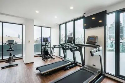a gym with two treadmills and two exercise bikes at SureStay Plus by Best Western Sukhumvit 2 in Bangkok