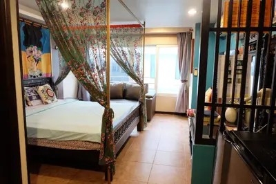 a bedroom with a canopy bed with a window at Sabai Sabai@Sukhumvit Hotel in Bangkok