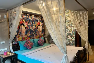 a bedroom with a canopy bed with a painting on the wall at Sabai Sabai@Sukhumvit Hotel in Bangkok