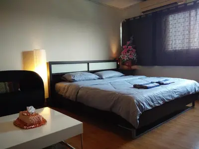 a bedroom with a large bed and a table at Renovate Room Near Impact in Ban Bang Phang