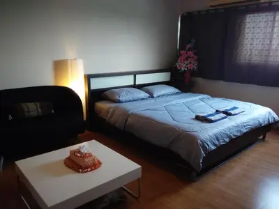 a bedroom with a bed and a coffee table at Renovate Room Near Impact in Ban Bang Phang