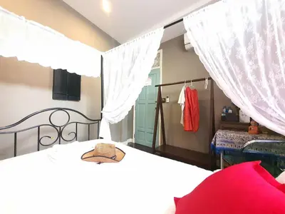 a bedroom with two beds with white curtains at The Unforgotten B&B in Bangkok