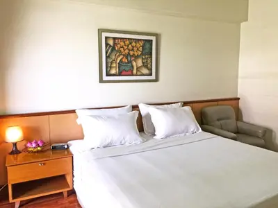 a bedroom with a white bed and a table and a painting at Rio Monte Residence in Bangkok