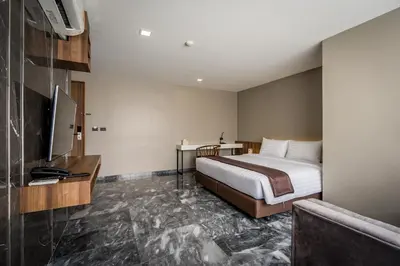 a hotel room with a bed and a television at Onix Hotel Bangkok in Bangkok