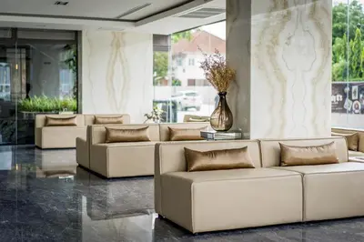 a lobby with couches and a vase with flowers at Onix Hotel Bangkok in Bangkok