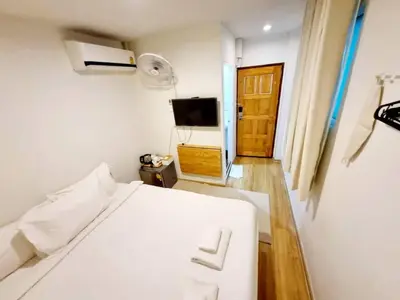 a bedroom with a white bed and a tv at K Home Asok in Bangkok