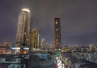 a city skyline at night with tall buildings at Backpack Station in Bangkok