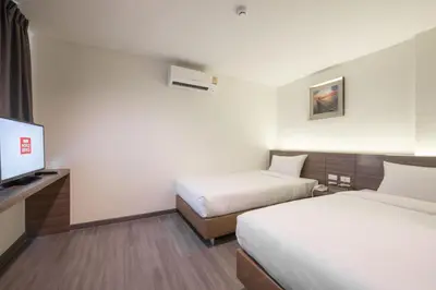 a hotel room with two beds and a flat screen tv at Sovereign Group Hotel at Pratunam in Bangkok