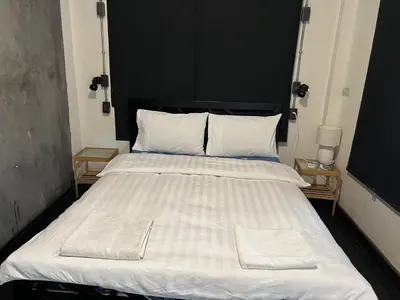 a large white bed with two white towels on it at Dreamcatcher Bangkok in Bangkok