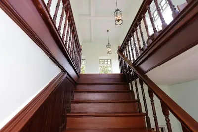 a wooden staircase with wooden railings in a house at Baan 2459 Heritage House in Bangkok