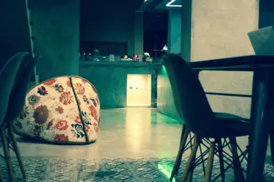 a table and chairs with a bag on the floor at Home'81 in Bangkok