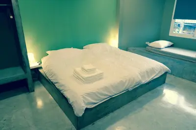a bed with a stack of towels on top of it at Home'81 in Bangkok