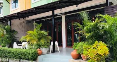 a patio with chairs and plants in front of a building at Home'81 in Bangkok