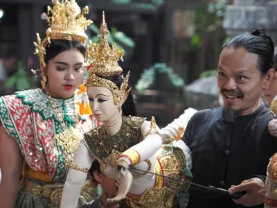 a man standing next to two people wearing crowns at 28 Place in Bangkok